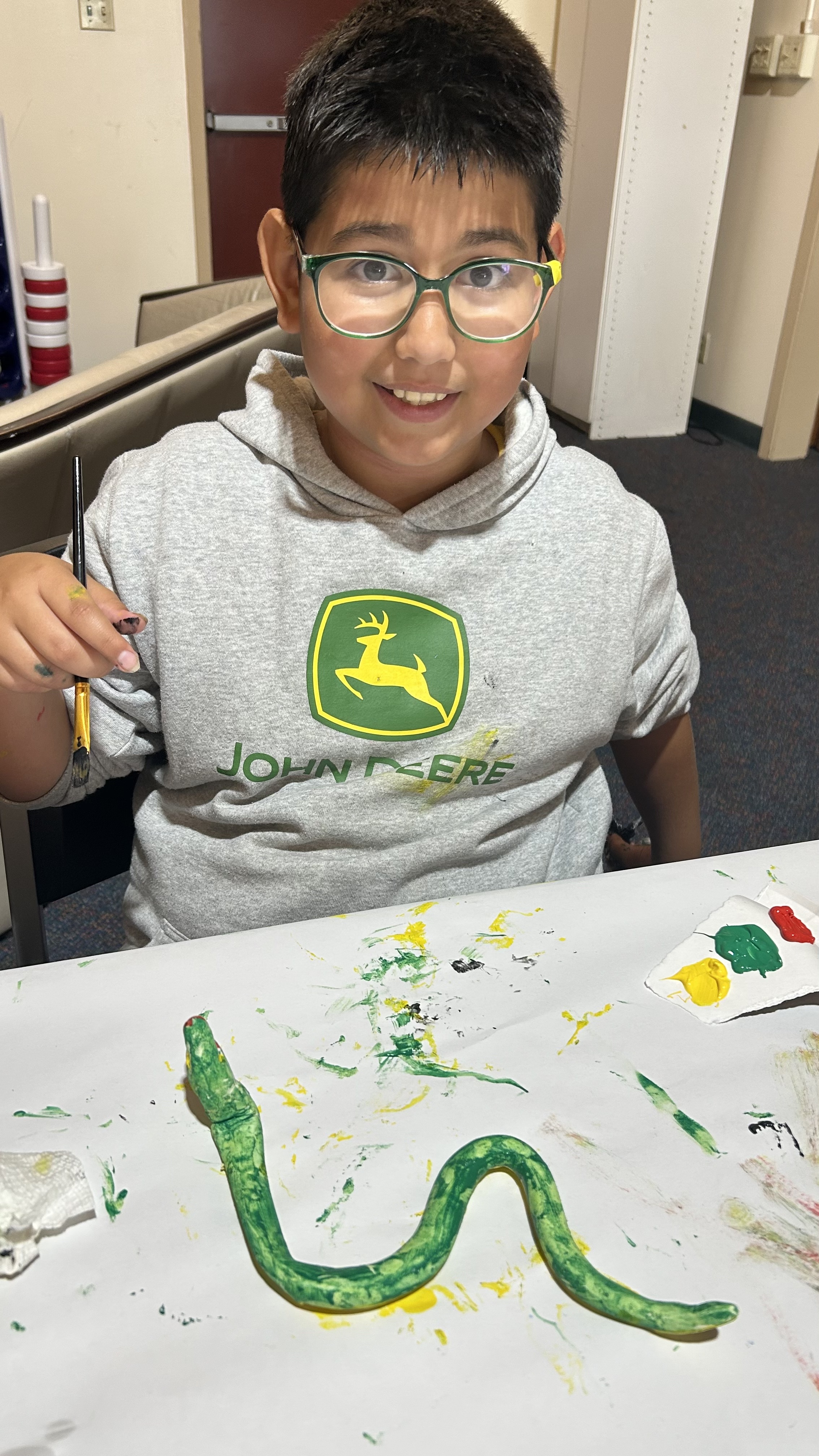 Student smiling with artwork